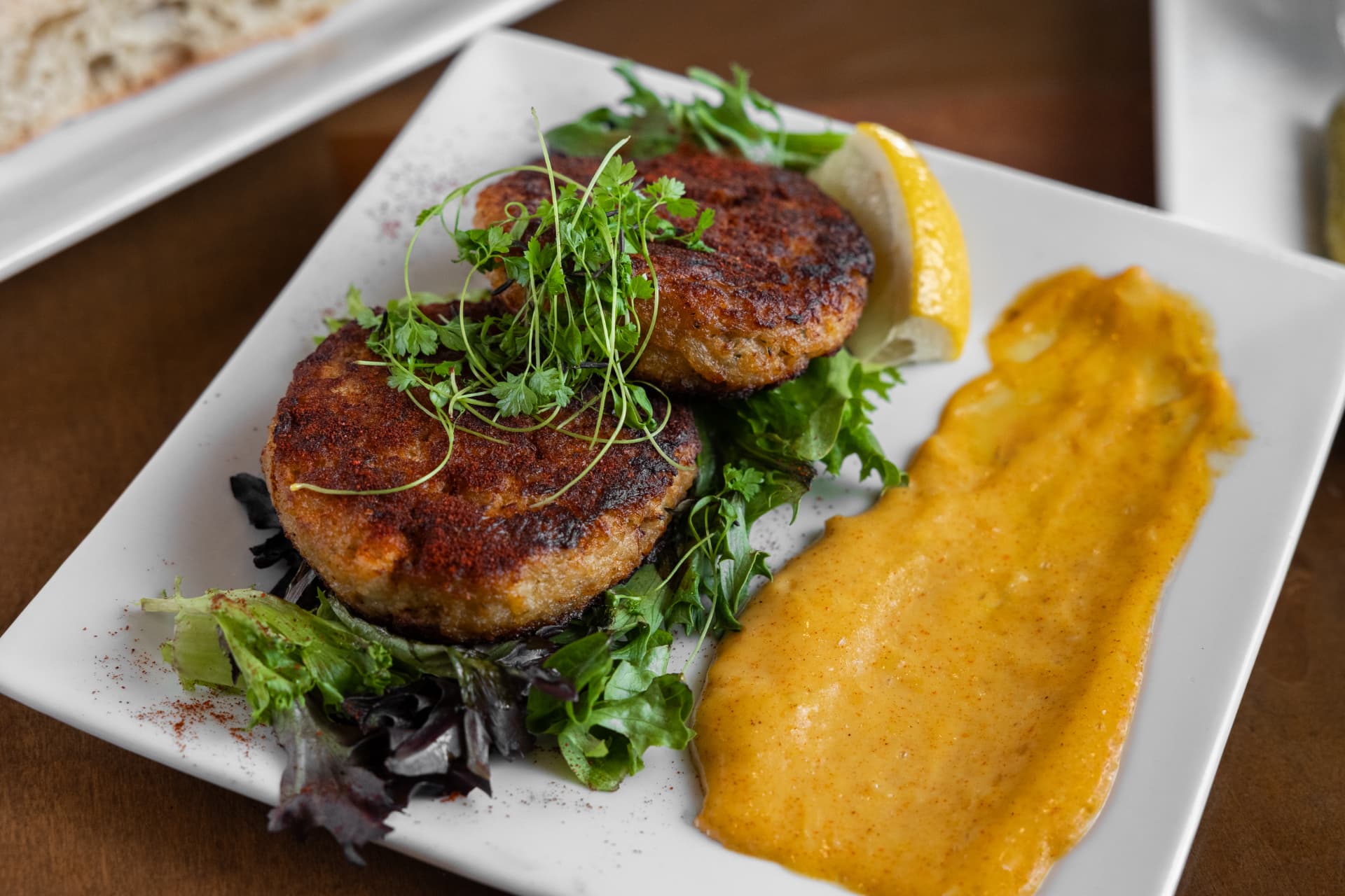 Crab cakes with greens, house remoulade, and lemon